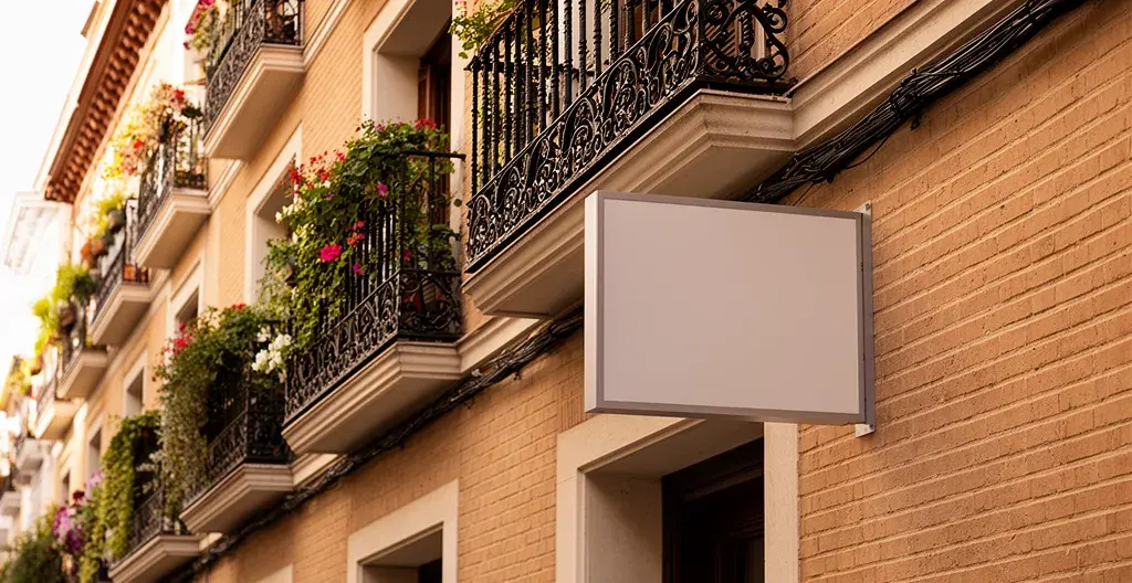 Cartel inmobiliario en fachada de edificio residencial madrileño